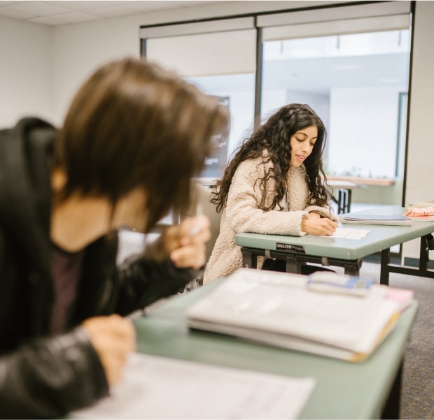 Two young adults doing work at a desk