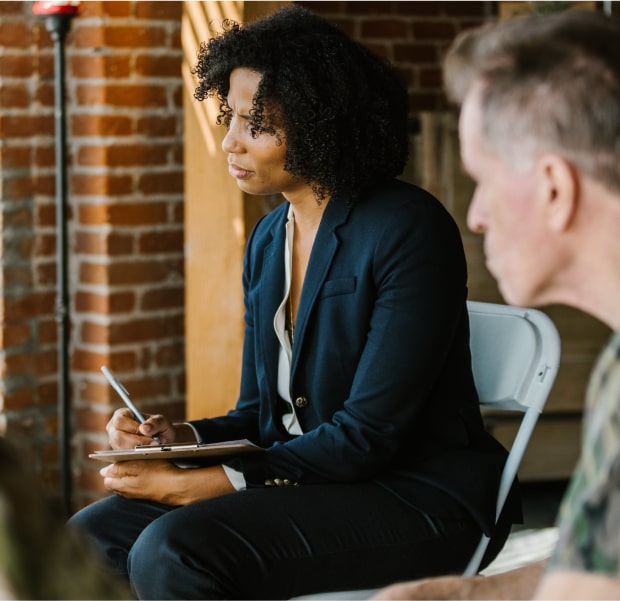 woman in a suit listening to someone speak